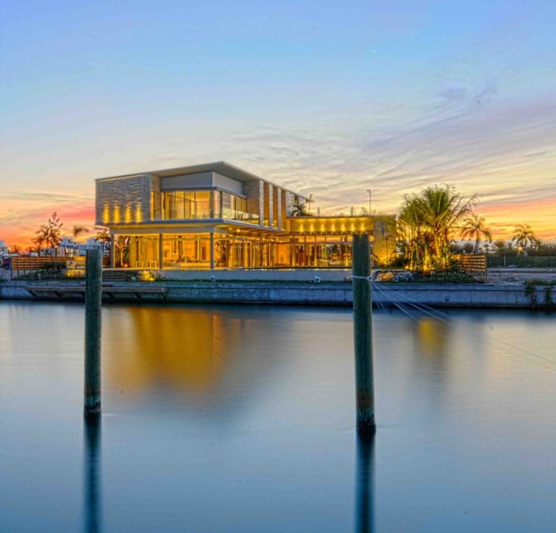 La villa iluminada al atardecer desde la marina